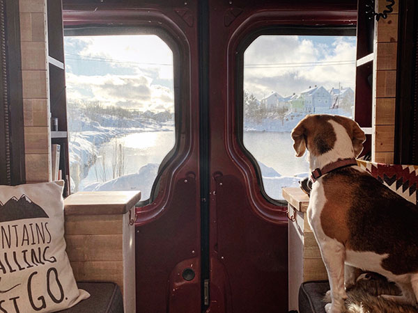 Staying cosy in our van thanks to our campervan heating, looking out over snowy Norway