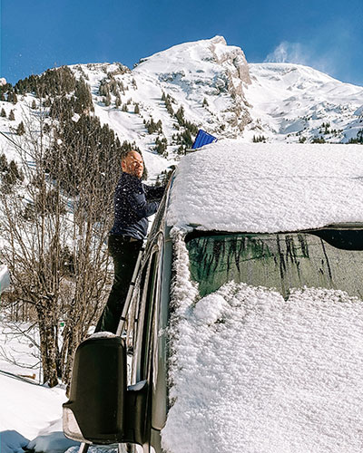 Clearing snow from the roof of our van so the solar can charge our battery for our campervan heating