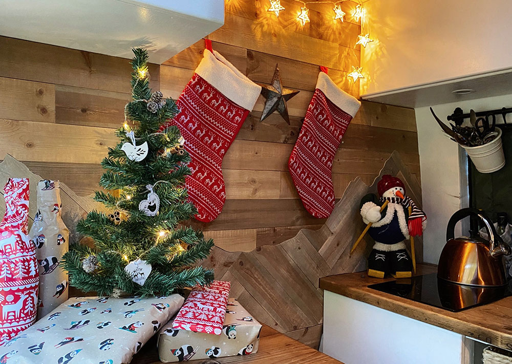 Christmas tree, decorations and gifts in our camper van, showcasing some of the best gifts for outdoor lovers.