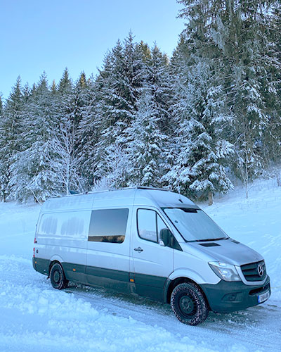 Our van parked in the snow with ice patterns showing the insulation