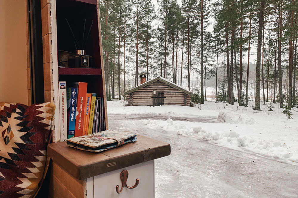 View out of our van parked in ice and snow with a small cabin