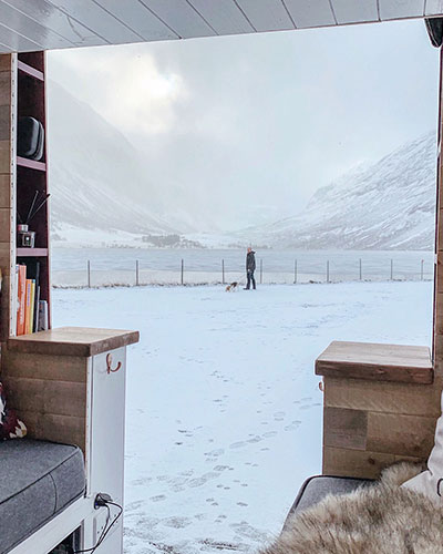 looking out of our camper van to a snowy lake