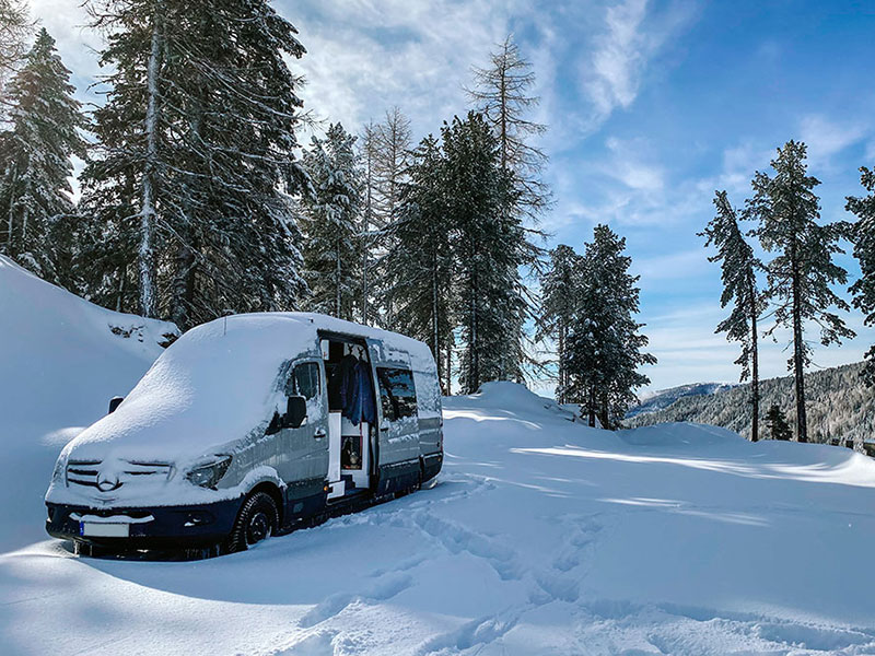 Our van parked in the snow at a free campervan parking spot in Austria