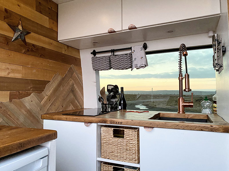 The kitchen in our van with cupboards and baskets