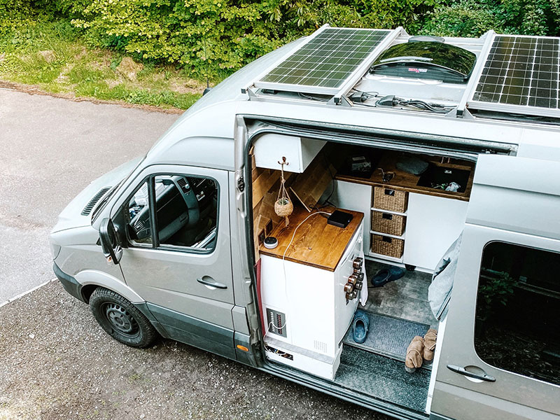 The front of our van with the side door open looking in to the kitchen and our new Maxxair fan on the roof