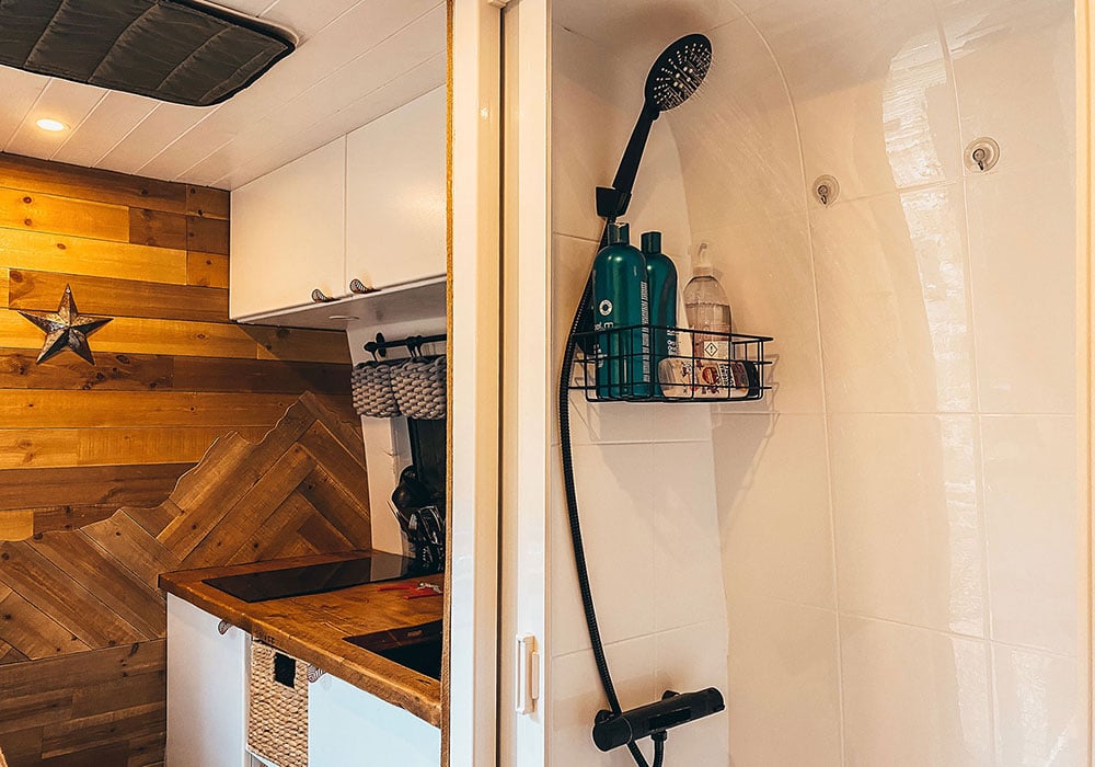 Hot water coming out of our shower with our tiny kitchen in the background