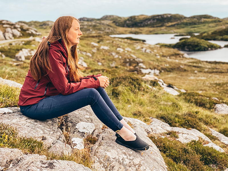 Wearing mahabis curve canvas slippers sat on a rock on Harris