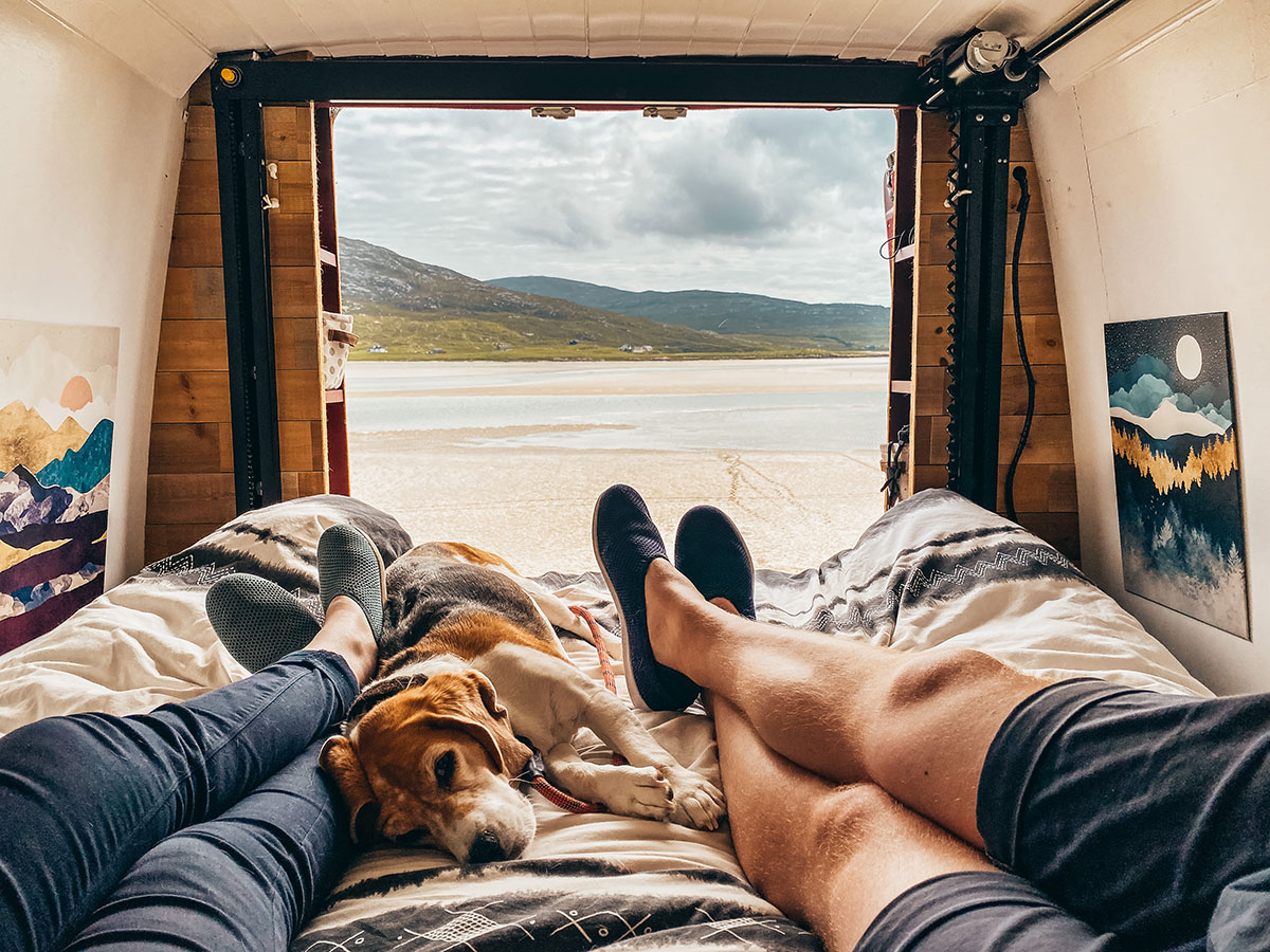 Wearing Mahabis camping slippers in our van looking out over a beach